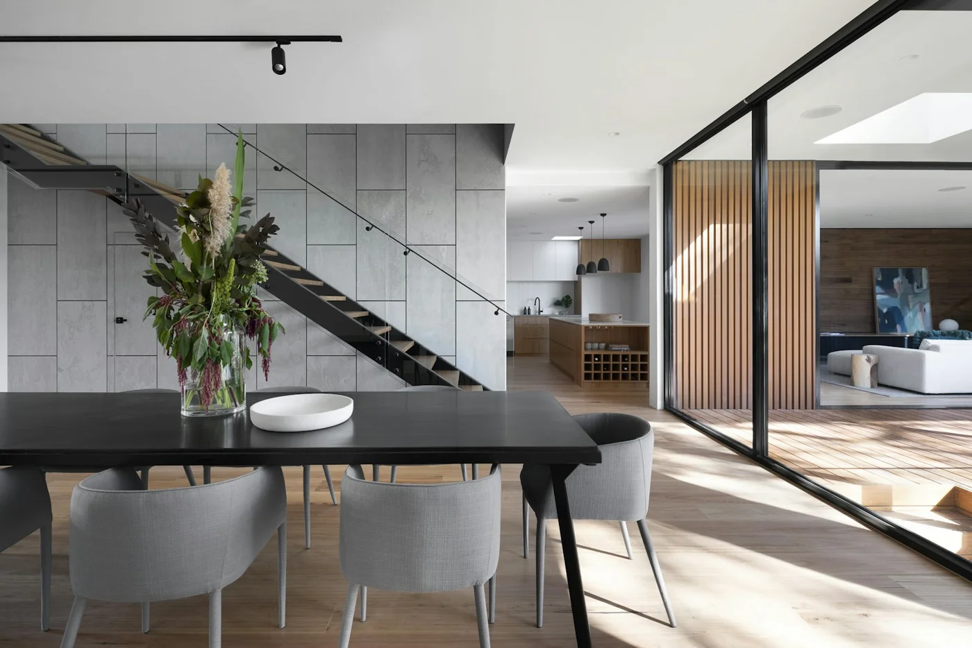 A spacious living area with a piano, dining furniture and natural light