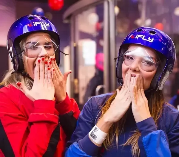 Visitors wearing iFLY helmets and flight equipment